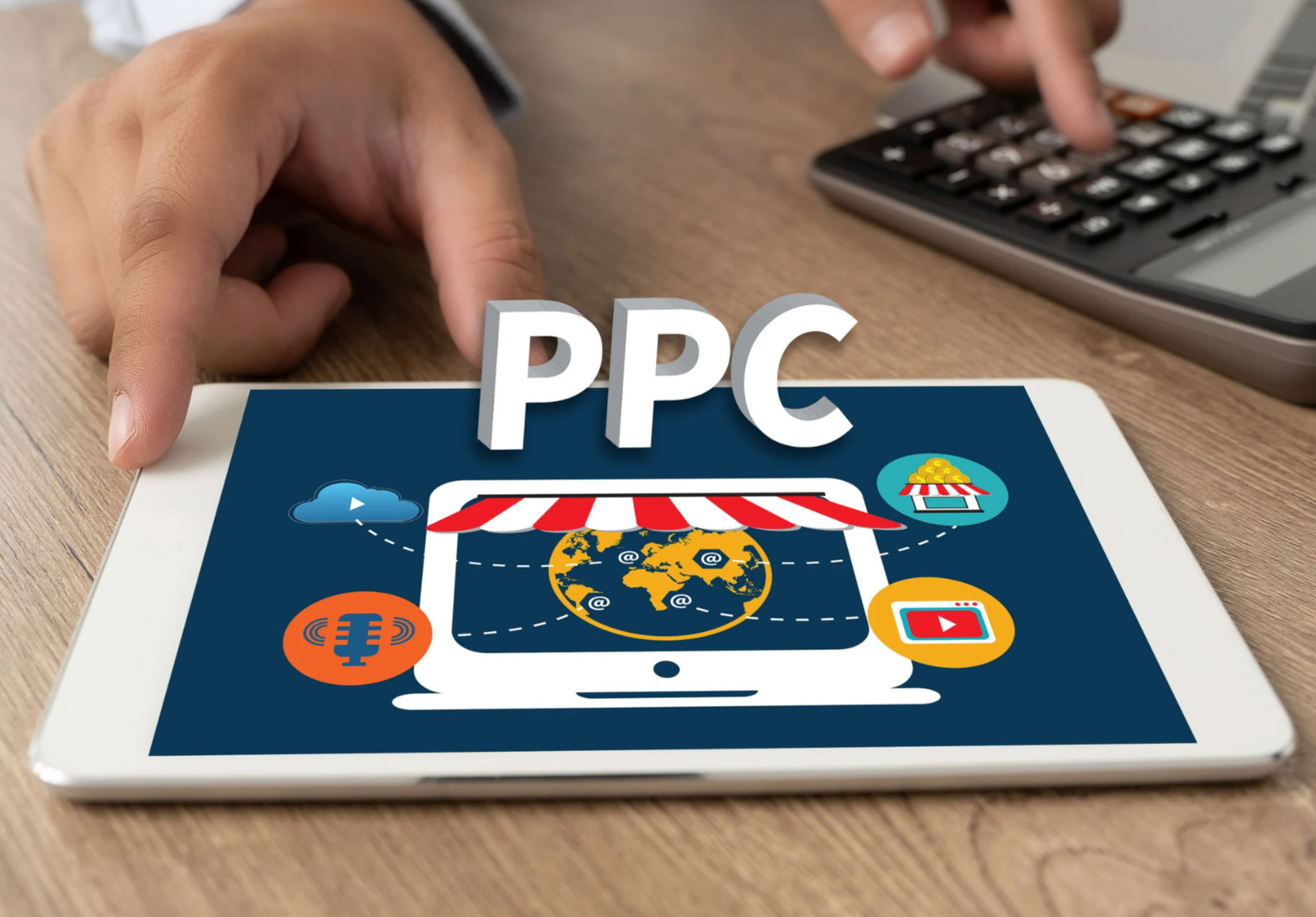 A tablet displaying a PPC graphic, with a person using a calculator in the background.